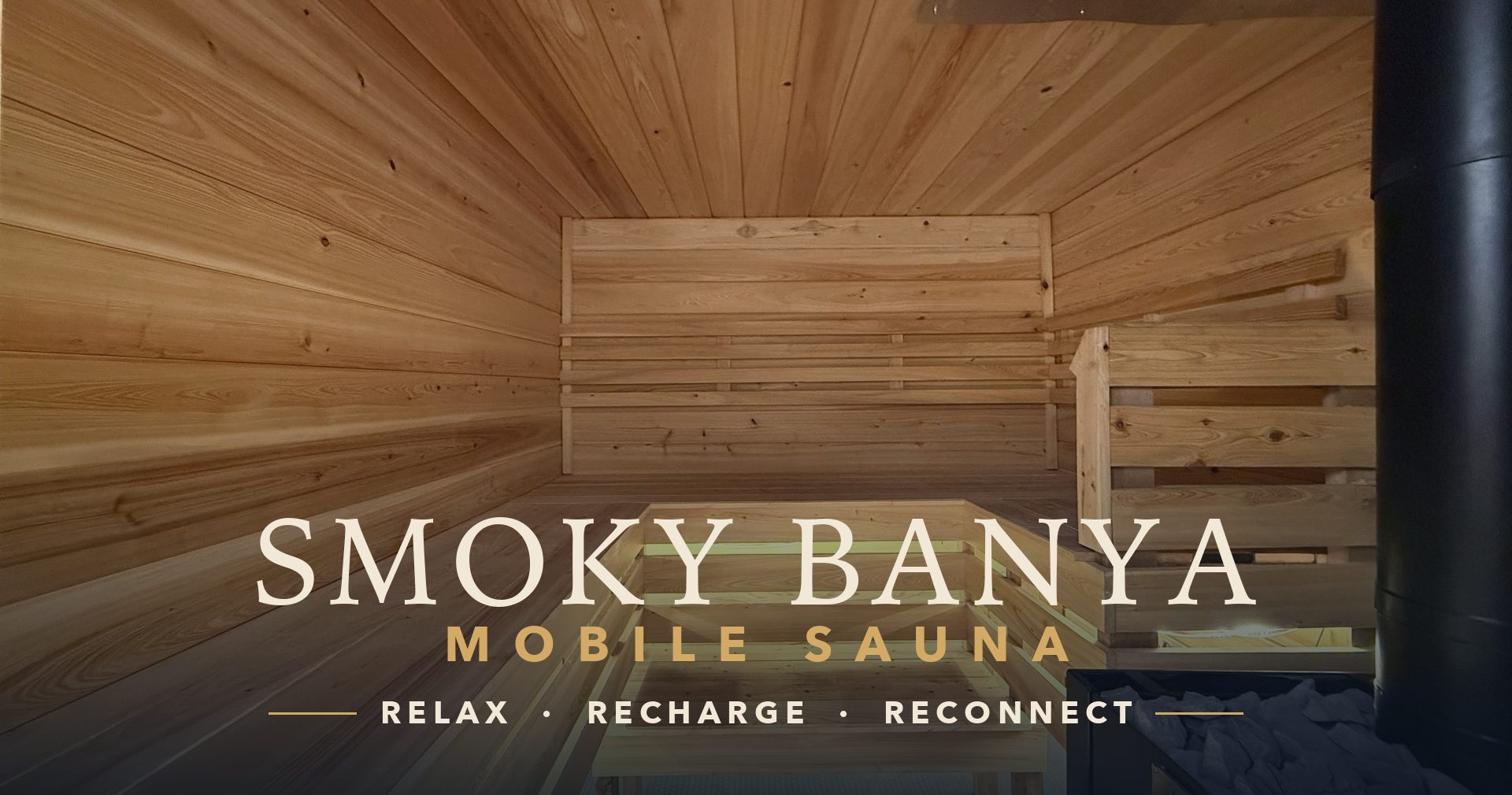 Inside the Smoky Banya mobile sauna — cedar walls and benches around the wood-fired stove, with the Smoky Banya Mobile Sauna name and Relax, Recharge, Reconnect
